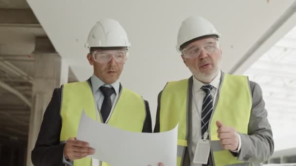 Cintura Dos Arquitectos Masculinos Con Trajes Formales Chalecos Reflectantes Gafas — Vídeo de stock