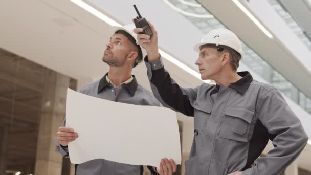 Tiro Médio Dois Construtores Caucasianos Masculinos Usando Chapéus Brancos Homem — Vídeo de Stock