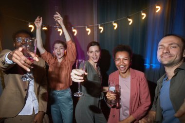 İçerde eğlenirken dans eden bir grup kaygısız insan, flaşla vurulmuş.