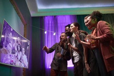 Bir grup genç evde eğlenirken internette arkadaşlarıyla konuşuyor.