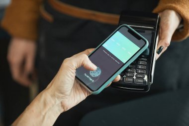 NFC tarafından kafede ödeme yaparken akıllı telefon kullanarak uygulamayı parmak iziyle etkinleştirmek için tanımlanamayan müşteri dokunmatik ekranının kapatılması
