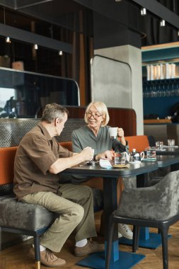 Üst düzey Kafkasyalı adam toplantı sırasında masada oturup arkadaşlarıyla konuşurken çay içiyor.