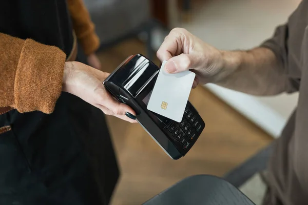 用无接触卡支付的无法辨认的顾客的特写镜头 并将其放在咖啡店服务员的终端上 — 图库照片