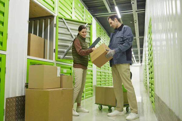 Two colleagues shipping and packing cardboard boxes working in warehouse