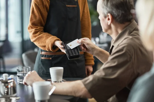 老年人在咖啡店与Nfc一起通过终端支付账单时使用非接触式卡 — 图库照片