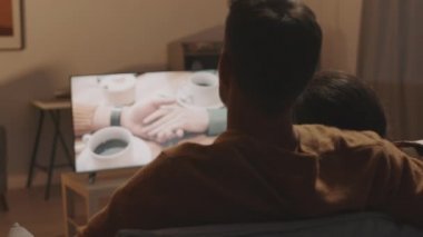 Tanımlanamayan romantik bir çiftin arka koltukta oturup televizyon izlemesi, televizyon izlemesi.