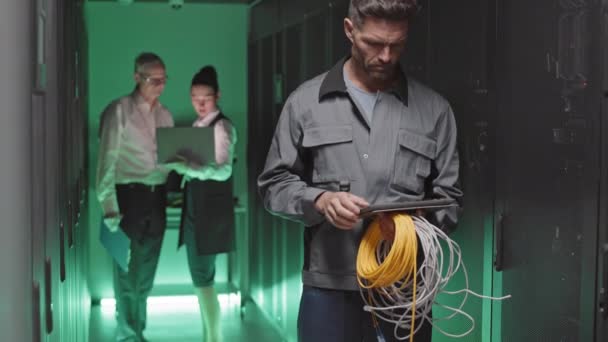 Kablo Tutan Raflar Arasında Koridorda Tablet Bilgisayar Kullanan Beyaz Erkek — Stok video