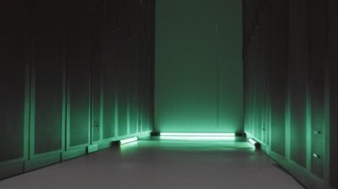 Veri merkezindeki iki dolabın arasında, yeşil ışıkla aydınlatılan ve kimsenin olmadığı dar bir açı.