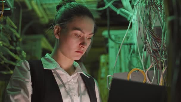 白种人女工程师在数据中心绿色灯火通明的技术室内工作时的胸部 — 图库视频影像