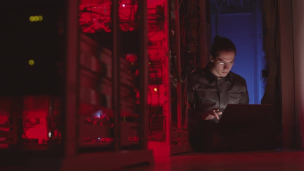 Wide Shot Young Male Caucasian Coder Sitting Floor Dark Red — Stock video