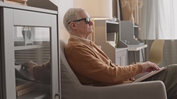 Side View Medium Slowmo Blind Elderly Man Black Eyeglasses Reading — Vídeos de Stock