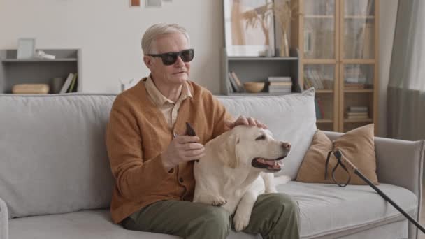 Medium Slowmo Blind Senior Man Sitting Sofa Home Holding Smartphone — Vídeos de Stock