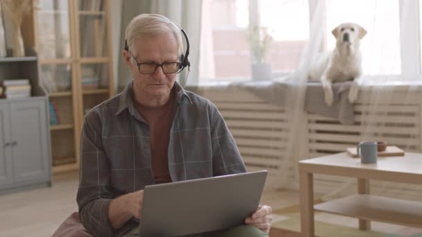 Medium Slowmo Contemporary Senior Man Casual Clothes Headset Working Laptop — Αρχείο Βίντεο