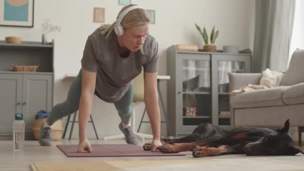 Kulaklık Tayt Tişört Giyen Yoga Minderinde Şınav Çeken Doberman Köpeğinin — Stok video