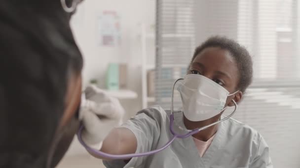 Inclinazione Giovane Veterinaria Africana Vestita Con Scrub Maschera Facciale Seduta — Video Stock