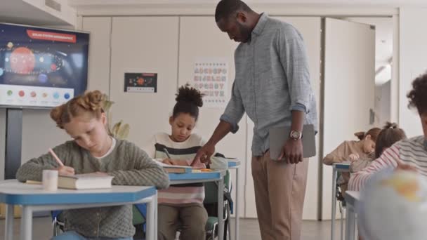 현대의 교실에서 책상에 시험을 젊은아 교사의 느림보가 시간에 여학생을 — 비디오