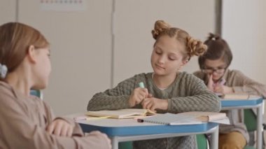 Sınıfta oturan güzel kızıl saçlı kız öğrencilerin orta yavaş PAN 'ı. Sınıf arkadaşı ona dönüp ders sırasında sohbet etmeye başladıklarında not defterine not alıyorlar.