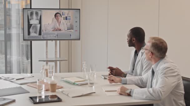 Lentidão Média Dois Radiologistas Multiétnicos Profissionais Sentados Mesa Sala Conferências — Vídeo de Stock