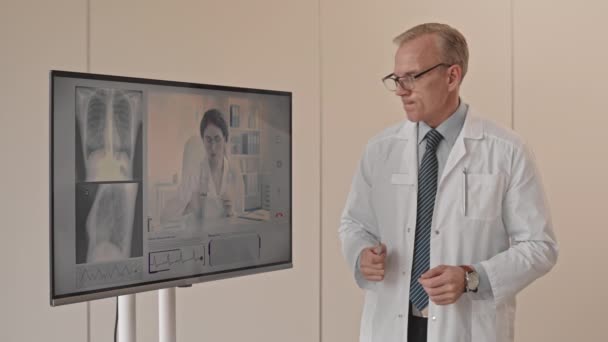 모니터를 방사선 전문의의 엑스레이 결과에 비디오 채팅을 사용하여 동료와 상담하는 — 비디오