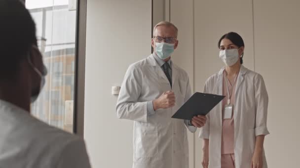 가리개와 유니폼을 아프리카 미국인 동료와 병원에서 일하는 의사와 간호사의 — 비디오