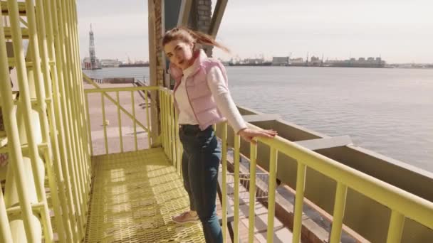 穿着牛仔裤和宽松夹克的快乐白人妇女的Pov 用黄色工业金属栅栏表演现代舞步 — 图库视频影像