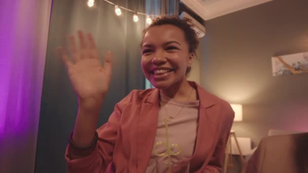 ハウスパーティーで一緒に祝うビデオチャットを通じて 彼らの友人を迎える若い多民族の人々のスローモーションとのクローズアップを追跡 — ストック動画