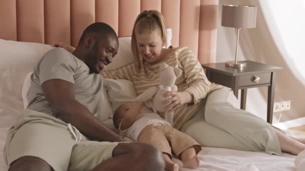 Média Longa Felizes Pais Diversos Deitados Cama Brincando Com Sua — Vídeo de Stock