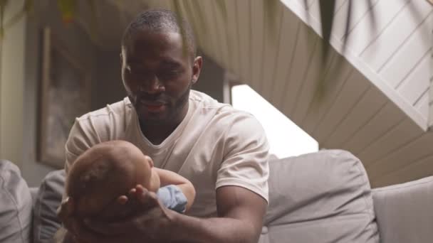 Medium Närbild Kärleksfull Ung Far Sitter Soffan Hemma Tittar Baby — Stockvideo