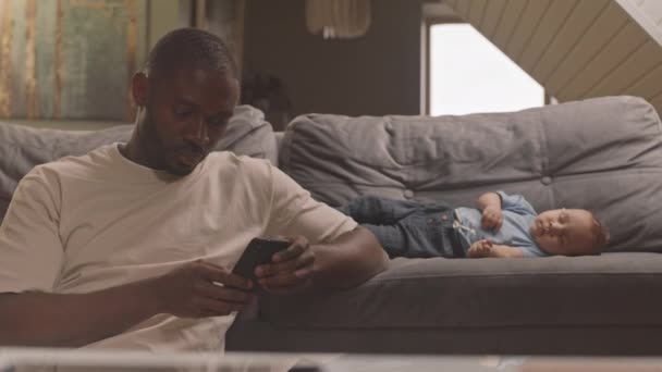 Cintura Homem Africano Carinhoso Sentado Por Sofá Casa Usando Smartphone — Vídeo de Stock