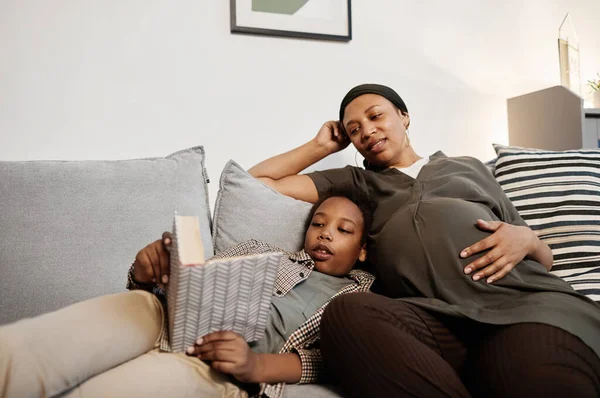 Embarazada afroamericana mujer relajante con hijo —  Fotos de Stock