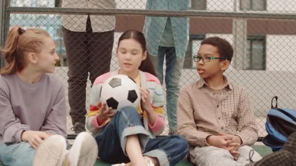 追踪一群在校园玩球的多种族未成年儿童的慢镜头 并在游戏中相互传递 — 图库视频影像