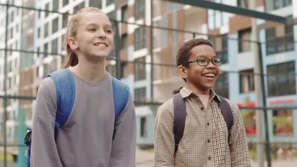 Mittlere Verlangsamung Von Zwei Multiethnischen Schulkindern Beim Ballspiel Mit Klassenkameraden — Stockvideo