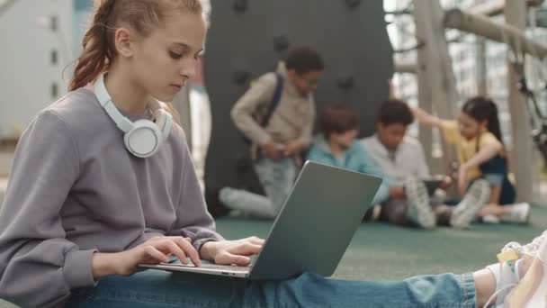 Powolne Ujęcie Białej Nastolatki Słuchawkach Odzieży Casualwear Studiującej Laptopie Placu — Wideo stockowe
