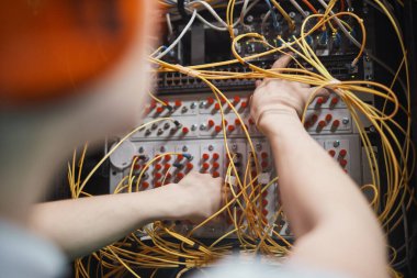 Close up of network engineer connecting cables in server room during maintenance work in data center, copy space