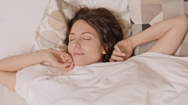 Верхній Вид Молоду Кавказьку Жінку Лежить Ліжку Прокидаючись Вранці Посміхаючись — стокове відео