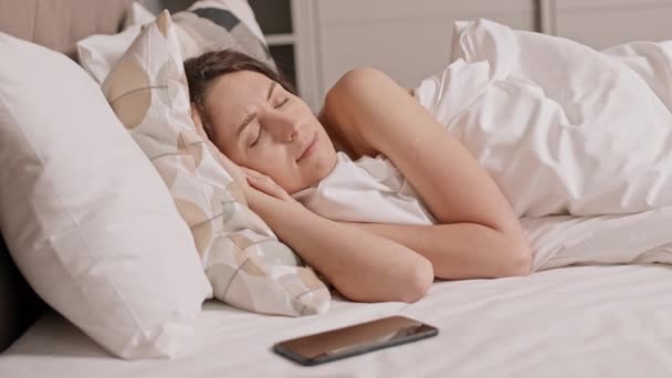 침대에 캅카스 여성의 아침에 일어나 스마트폰을 찡그리고 잠들어 — 비디오
