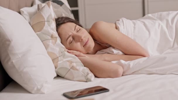 침대에 캅카스 여성의 아침에 일어나 스마트폰을 보면서 일어나는 — 비디오