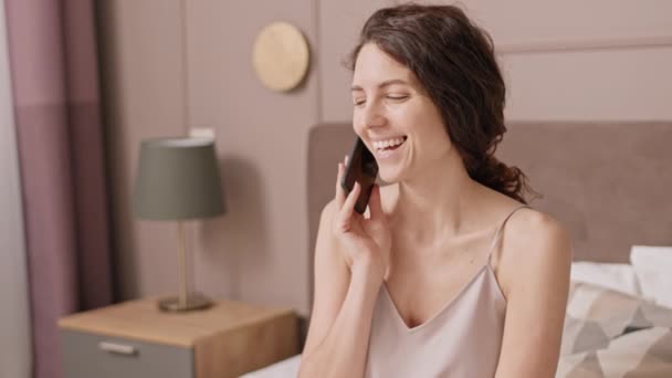Στήθος Χαρούμενης Καυκάσιας Γυναίκας Που Κάθεται Στο Κρεβάτι Χρησιμοποιεί Smartphone — Αρχείο Βίντεο