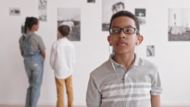 Waist African Boy Wearing Glasses Wired Headphones Standing Museum Contemporary — Stock Video