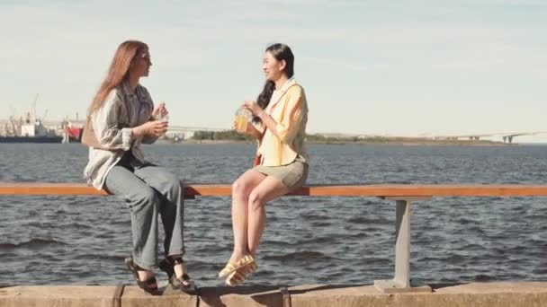 Wide Shot Two Girlfriends Sitting Embankment Beautiful View River Chatting — Stock Video