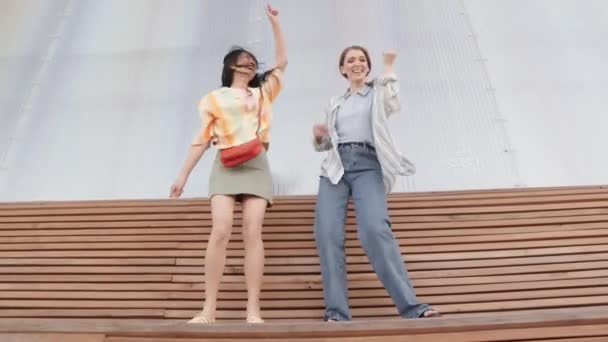 Низкоугольный Полный Снимок Двух Веселых Молодых Женщин Повседневной Одежде Танцующих — стоковое видео