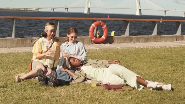 Young Multiethnic Women Spending Summertime Together Resting Sunbathing Grass Waterfront — Stock Video