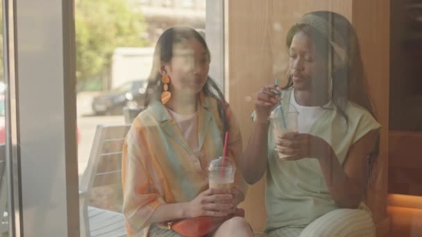 Window Waist Shot Two Young Multiethnic Women Casualwear Drinking Iced — Stock Video