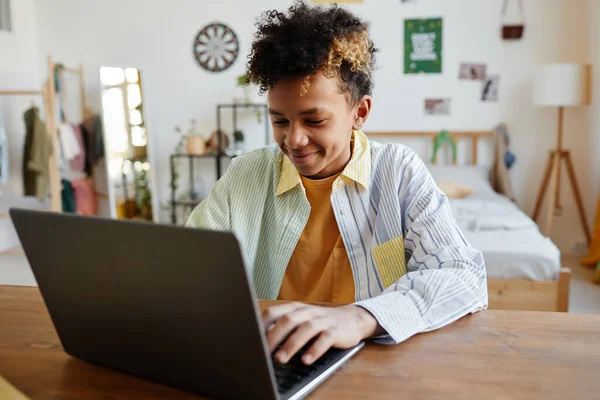 Sorrindo adolescente menino usando laptop — Fotografia de Stock