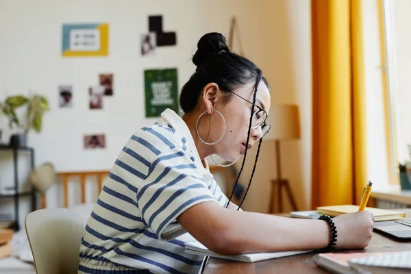 Tiener meisje doet huiswerk zijaanzicht — Stockfoto