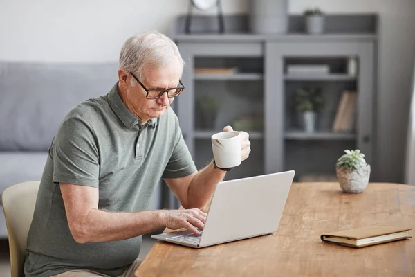 Старший чоловік використовує ноутбук Мінімум — стокове фото
