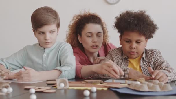 Medio Primer Plano Joven Mujer Caucásica Ayudando Dos Chicos Multiétnicos — Vídeos de Stock