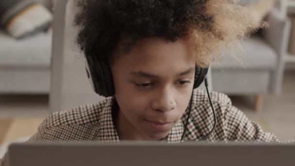 Wysokie Zbliżenie Trzynastoletniego Chłopca Noszącego Słuchawki Mikrofonem Siedzącego Pokoju Rozmawiającego — Wideo stockowe