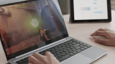 Tanımlanamayan, elleri çerçeveli, odasında masasında oturan, taşınabilir bilgisayarla oyundaki golleri atan kişiler.