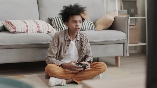 Kompletní Záběr Třináctiletého Afrického Chlapce Sedícího Doma Gauči Držícího Ovladač — Stock video